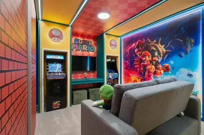 a stuffed toy sitting in a room with a video game at 3BR Home w Game Room Near Disney in Kissimmee