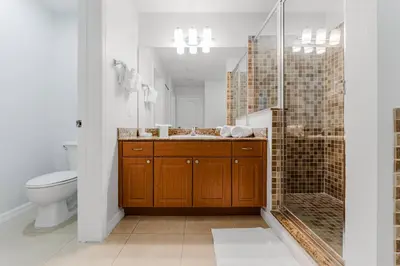 a bathroom with a toilet and a sink and a shower at Cozy Apartment at The Point in Orlando
