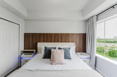 a bedroom with a white bed with a large window at Cozy Apartment at The Point in Orlando