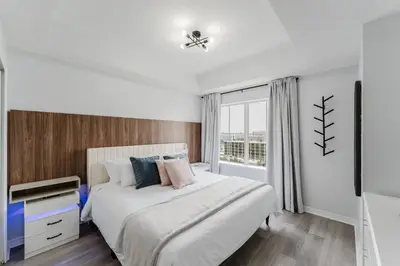 a white bedroom with a bed and a window at Cozy Apartment at The Point in Orlando
