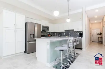 a kitchen with white cabinets and stainless steel appliances at Luxury Condo Near Disney and Resort Access in Kissimmee
