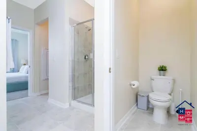 a bathroom with a toilet and a walk in shower at Luxury Condo Near Disney and Resort Access in Kissimmee