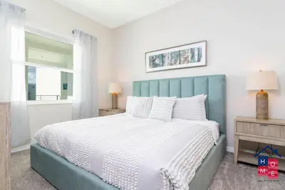 a bedroom with a large bed with a blue headboard at Luxury Condo Near Disney and Resort Access in Kissimmee