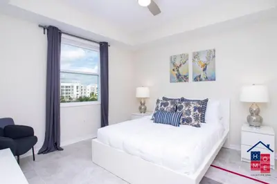 a white bedroom with a bed and a window at Condo near Disney with Resort in Kissimmee