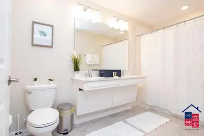 a white bathroom with a toilet and a sink at Condo near Disney with Resort in Kissimmee