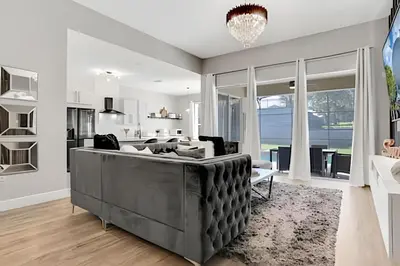 a living room with a couch and a kitchen at Luxo 5Q Windsor Hills c/ Piscina e Game Room in Orlando