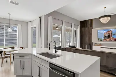 a kitchen with white countertops and a dining room at Luxo 5Q Windsor Hills c/ Piscina e Game Room in Orlando