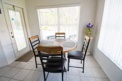 a dining room with a wooden table and chairs at Free pool-spa heat - Near Disney - Nature view in Orlando