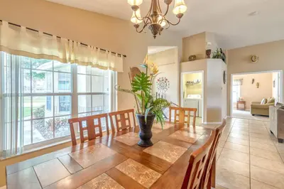 a dining room with a table with a vase on it at Safari Lodge in Orlando