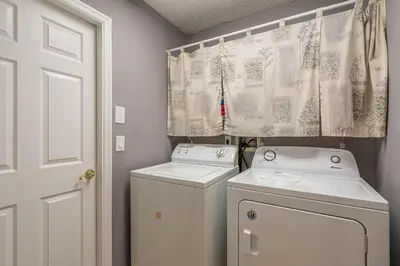 a laundry room with two washing machines and a curtain at Pool Paradise in Orlando