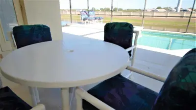 a white table and chairs and a swimming pool at Minnie's Marvel in Kissimmee