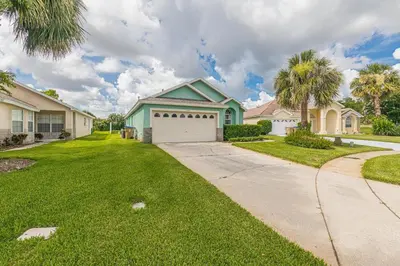 a house with a white garage and palm trees at The Boat House in Orlando
