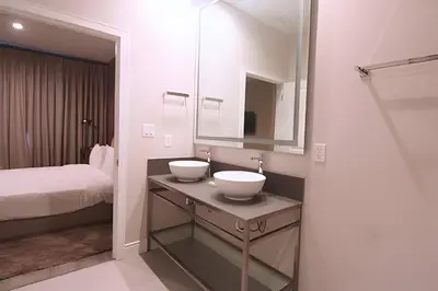 a white bathroom with two sinks and a bed at Casa Luxo 4 Suítes no Magic Village in Kissimmee
