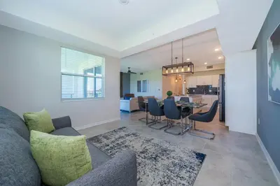 a living room with a couch and a table with chairs at Condo in the Heart of Orlando - 10 Min from Disney in Kissimmee