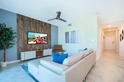a living room with a white couch and a tv at Condo in the Heart of Orlando - 10 Min from Disney in Kissimmee