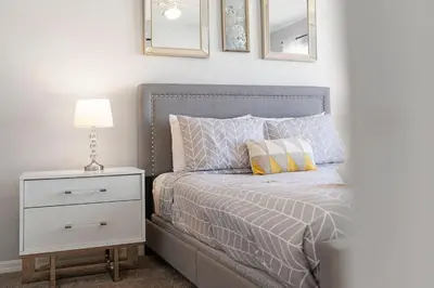 a bedroom with a bed with a nightstand and a lamp at Casa 4Q perto da Disney + Piscina no Clube in Kissimmee