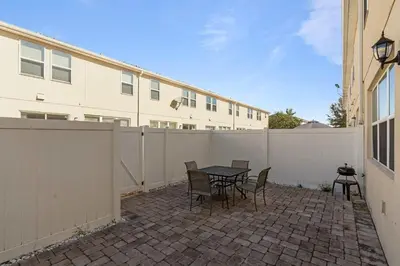 a patio with a table and chairs and a fence at Casa 4Q perto da Disney + Piscina no Clube in Kissimmee