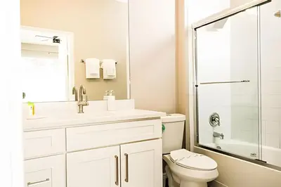 a bathroom with a toilet and a sink and a shower at Casa 4Q Windsor Hills c/ Piscina e Game Room in Orlando