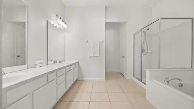 a white bathroom with two sinks and a bath tub at Upstay Newly Renovated Family Retreat Home Near Epic Universe in Orlando