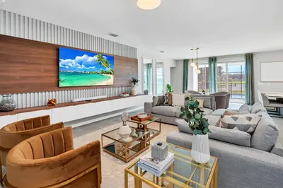 a living room with a couch and a tv on a wall at Disney-Adjacent 15Bd15Ba Oasis With Private Pool in Kissimmee