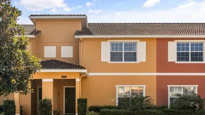 a large orange house with windows at Family Resort Getaway w Pool & Patio near Disney in Kissimmee