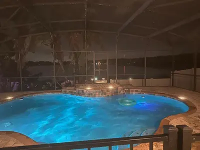 a large swimming pool in a building at night at Orlando Lakefront Pool Villa 25 min Disney & Univ in Orlando