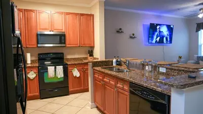 a kitchen with wooden cabinets and a counter top at Stylish and cozy townhome! in Orlando