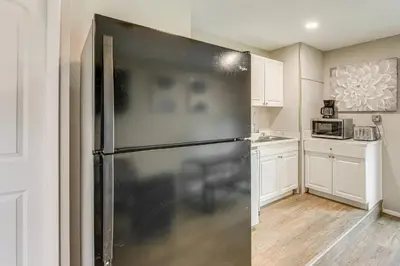 a black refrigerator in a kitchen with white cabinets at Townhome with Fenced Yard in Orlando Suburbs! in Orlando