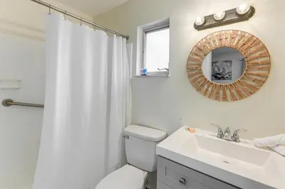 a bathroom with a toilet and a sink and a mirror at Townhome with Fenced Yard in Orlando Suburbs! in Orlando