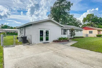 a white house with a driveway in a yard at Townhome with Fenced Yard in Orlando Suburbs! in Orlando