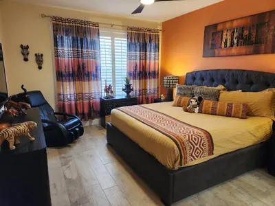 a bedroom with a large bed and a chair at Mickeys Magical Escape in Orlando