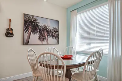 a dining room with a table and chairs and a palm tree at A Parrot's Live For Me Cottage With Private Pool Near Disney With Margaritaville Resort & Island H20 Waterpark Access - 8028Sh in Orlando
