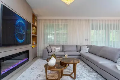 a living room with a couch and a large tv at Brand New 9 Bedroom Single Family Storey Lake 18ST in Kissimmee
