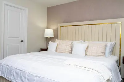 a large white bed with white pillows in a bedroom at Brand New 9 Bedroom Single Family Storey Lake 18ST in Kissimmee