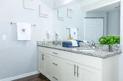 a white bathroom with a sink and a mirror at Comfy and Spacious House in Kissimmee