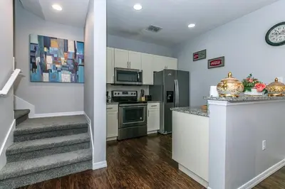 a kitchen with white cabinets and a staircase in a house at Comfy and Spacious House in Kissimmee