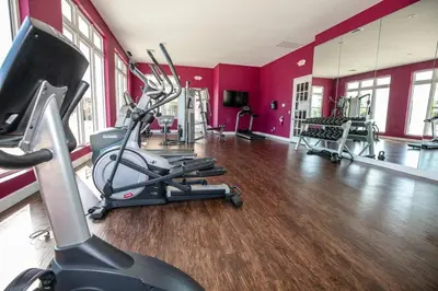 a gym with red walls and a gym with tread machines at Comfy and Spacious House in Kissimmee