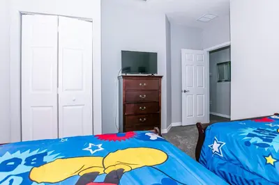 a bedroom with a bed and a television and a dresser at Comfy and Spacious House in Kissimmee