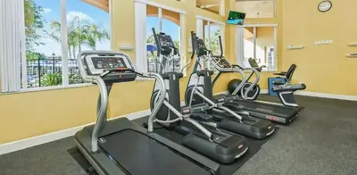a row of cardio machines in a gym at Modern Kissimmee Townhouse near Disney townhouse in Kissimmee