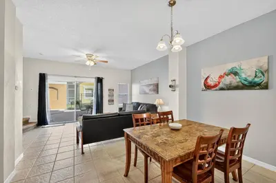 a dining room and living room with a table and chairs at Modern Kissimmee Townhouse near Disney townhouse in Kissimmee