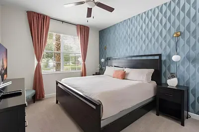 a bedroom with a bed and a blue wall at Casa 5Q c/ Piscina Sul e Game Room – Storey Lake in Kissimmee