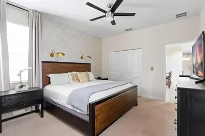 a bedroom with a bed and a ceiling fan at Casa 5Q c/ Piscina Sul e Game Room – Storey Lake in Kissimmee
