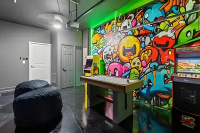 a room with a colorful wall with a pool table at Casa 5Q c/ Piscina Sul e Game Room – Storey Lake in Kissimmee