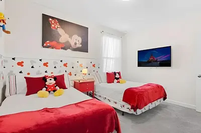 a bedroom with two beds and a teddy bear on the bed at Casa 6Q c/ Piscina & Quartos Temáticos in Kissimmee
