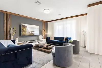 a living room with blue couches and a tv at Casa 6Q c/ Piscina & Quartos Temáticos in Kissimmee