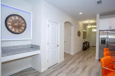 a living room with a clock on the wall at Casa 6Q c/ Piscina – 10 Min da Disney in Kissimmee