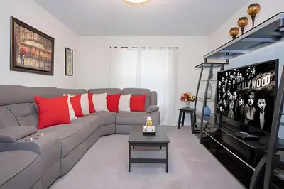 a living room with a couch and a tv at Casa 6Q c/ Piscina – 10 Min da Disney in Kissimmee