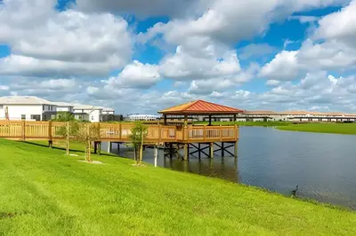 a wooden dock on the water with a gazebo at Casa 6Q c/ Piscina – 10 Min da Disney in Kissimmee