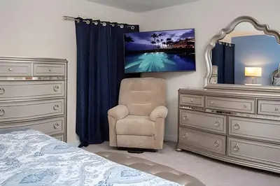 a bedroom with a bed and a chair and a dresser at Casa 6Q c/ Piscina – 10 Min da Disney in Kissimmee