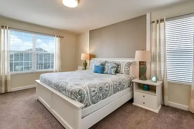 a bedroom with a bed and a large window at Casa 6Q c/ Piscina + Temas Disney – Storey Lake in Kissimmee
